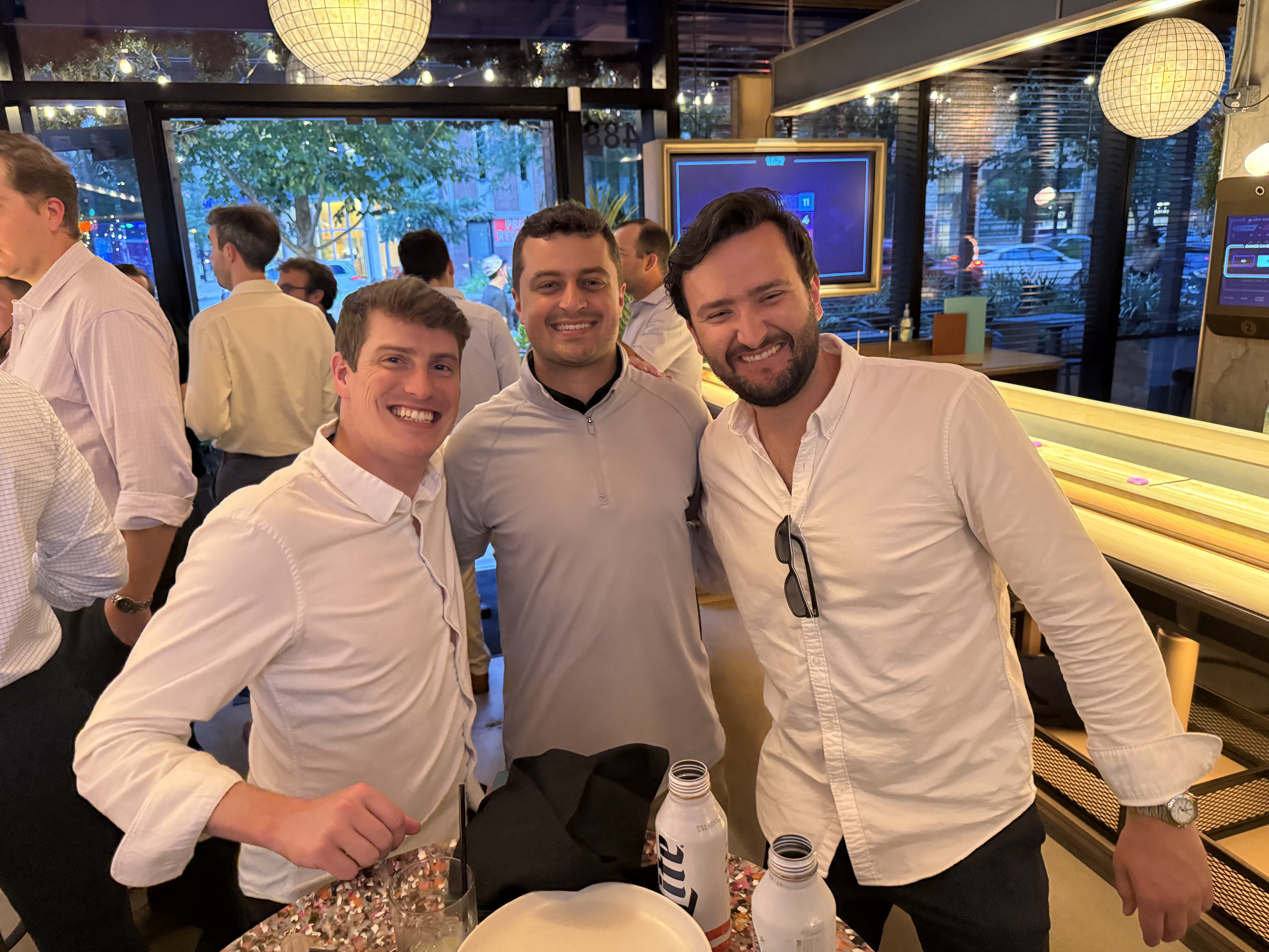 Three Waylin Partners colleagues smiling together at the Tampa offsite social